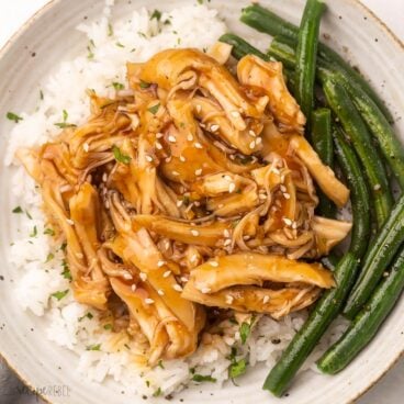 shredded honey garlic chicken on white rice and a side of green beans.