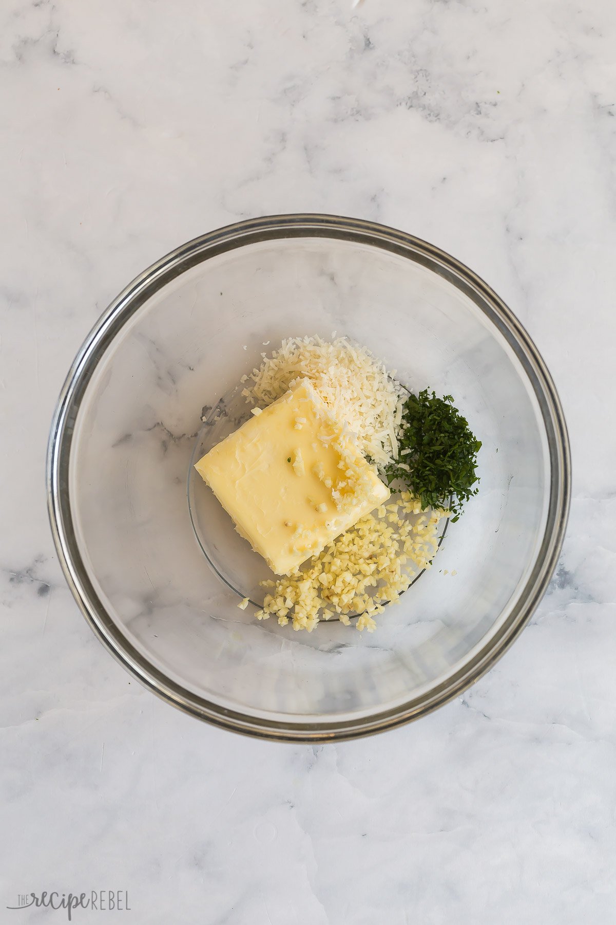 glass bowl with butter, garlic, parsley, and parmesan cheese.