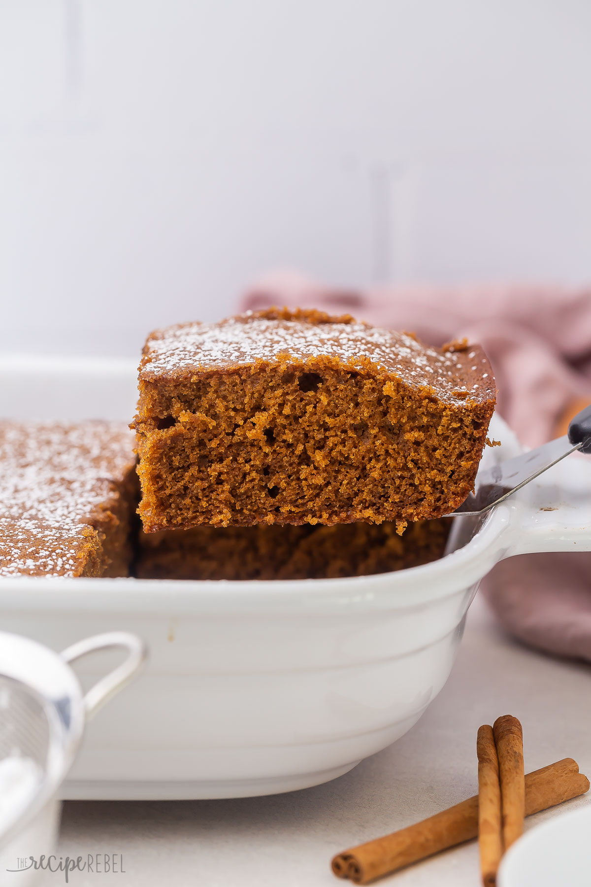 a piece of gingerbread coming out of a white pan on a scoop.