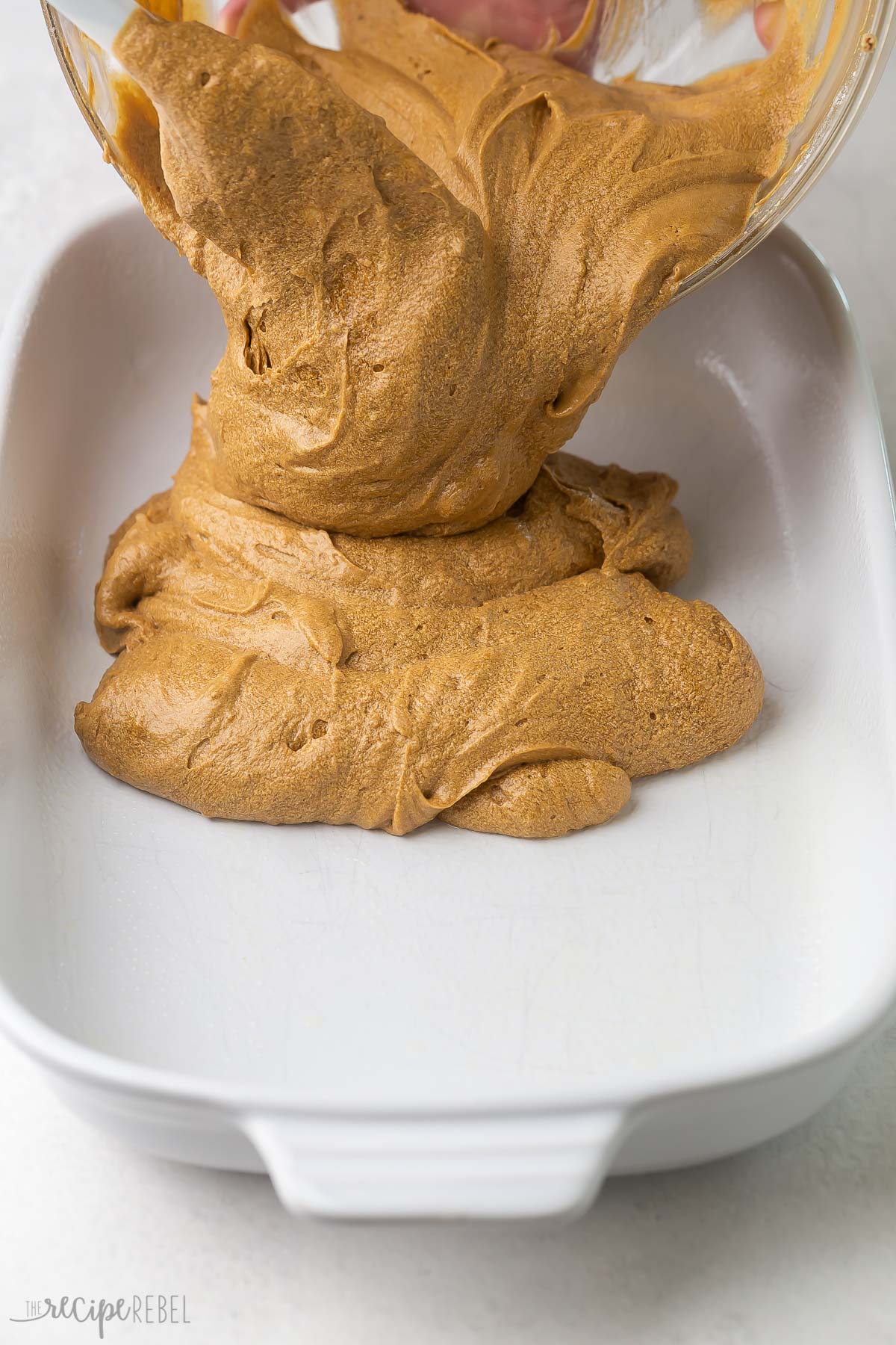 pouring gingerbread mixture into white pan.