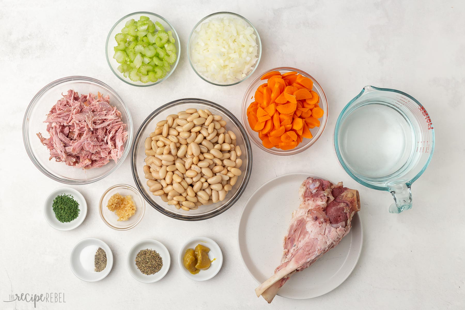 This Ham and Bean Soup is so hearty and flavorful and the perfect way to use up any leftover ham! It's loaded with veggies, ham, white kidney beans, and so much flavor. #soup #recipe | dinner recipe | dinner ideas | healthy recipe | healthy soup | healthy dinner | leftover ham ham and bean soup ingredients in glass bowls.