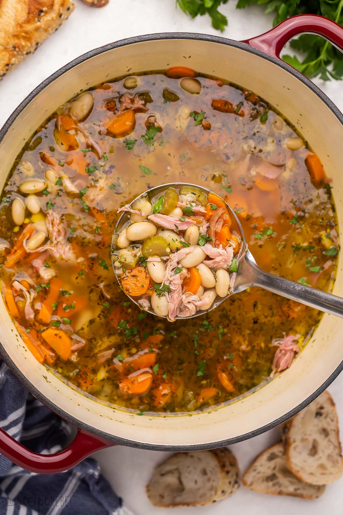 scooping ham and bean soup out of dutch oven.