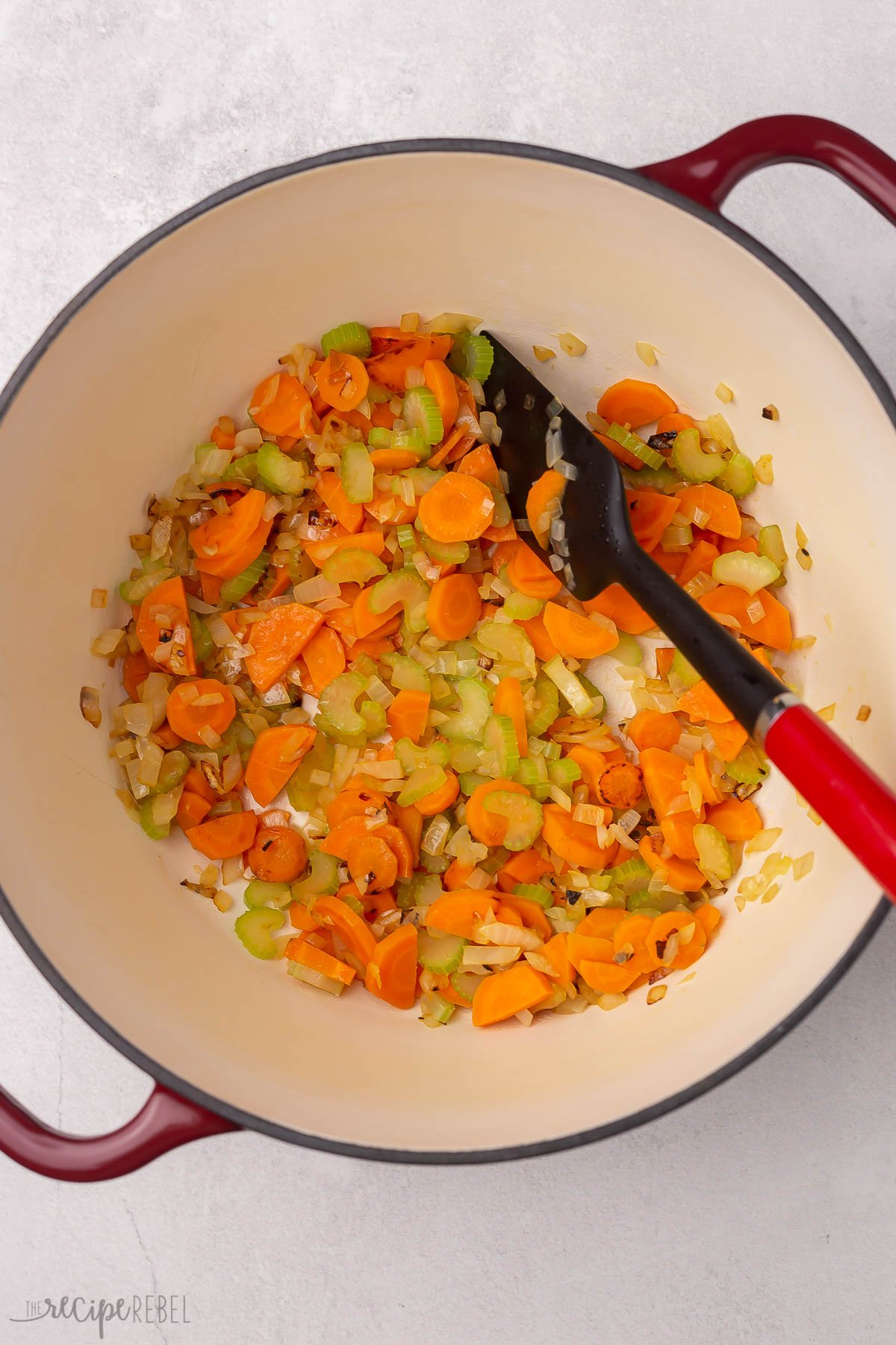 sauteing carrots and onions in pot.