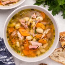 a white bowl of ham and bean soup.