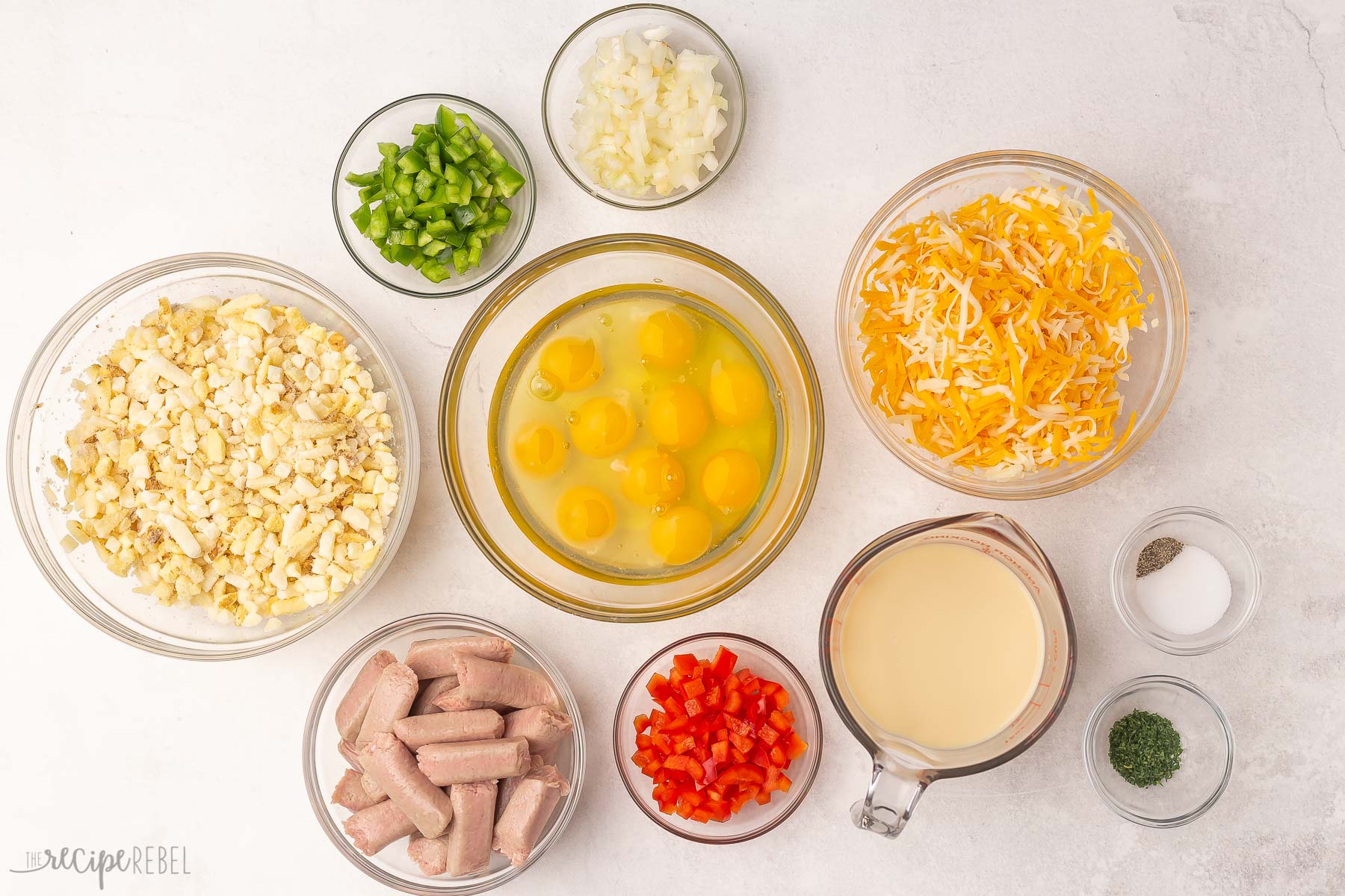 Top view of hashbrown breakfast casserole ingredients in glass bowls.