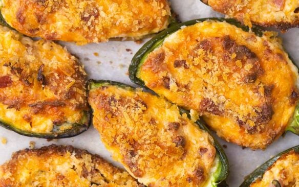 close up of jalapeno poppers on parchment paper.