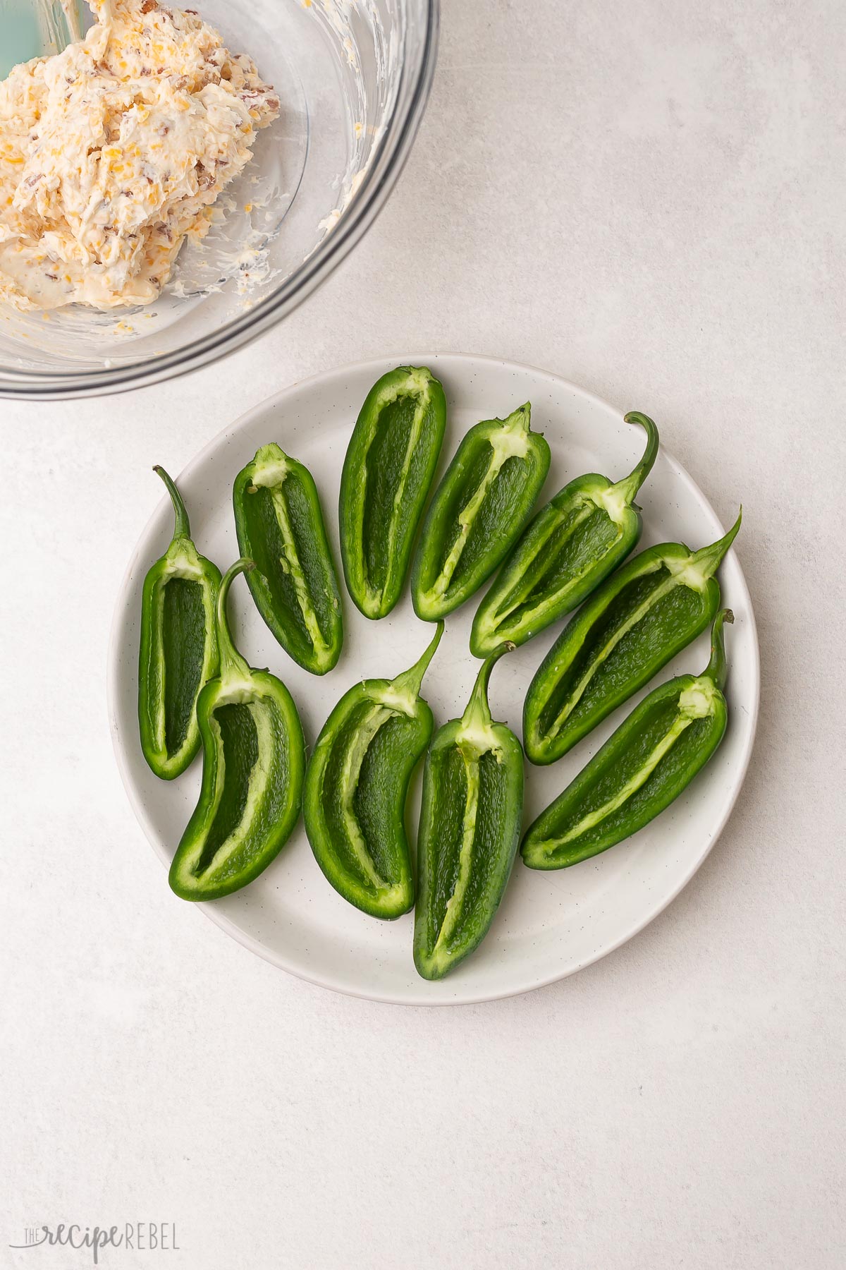 halved jalapenos on a white plate.