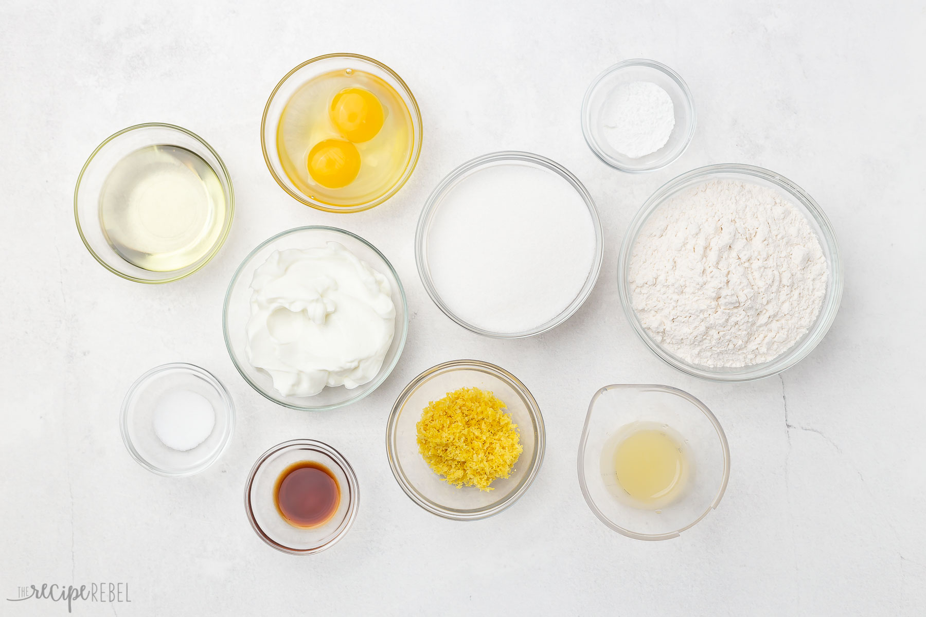 Top view of ingredients in glass bowls on grey surface.