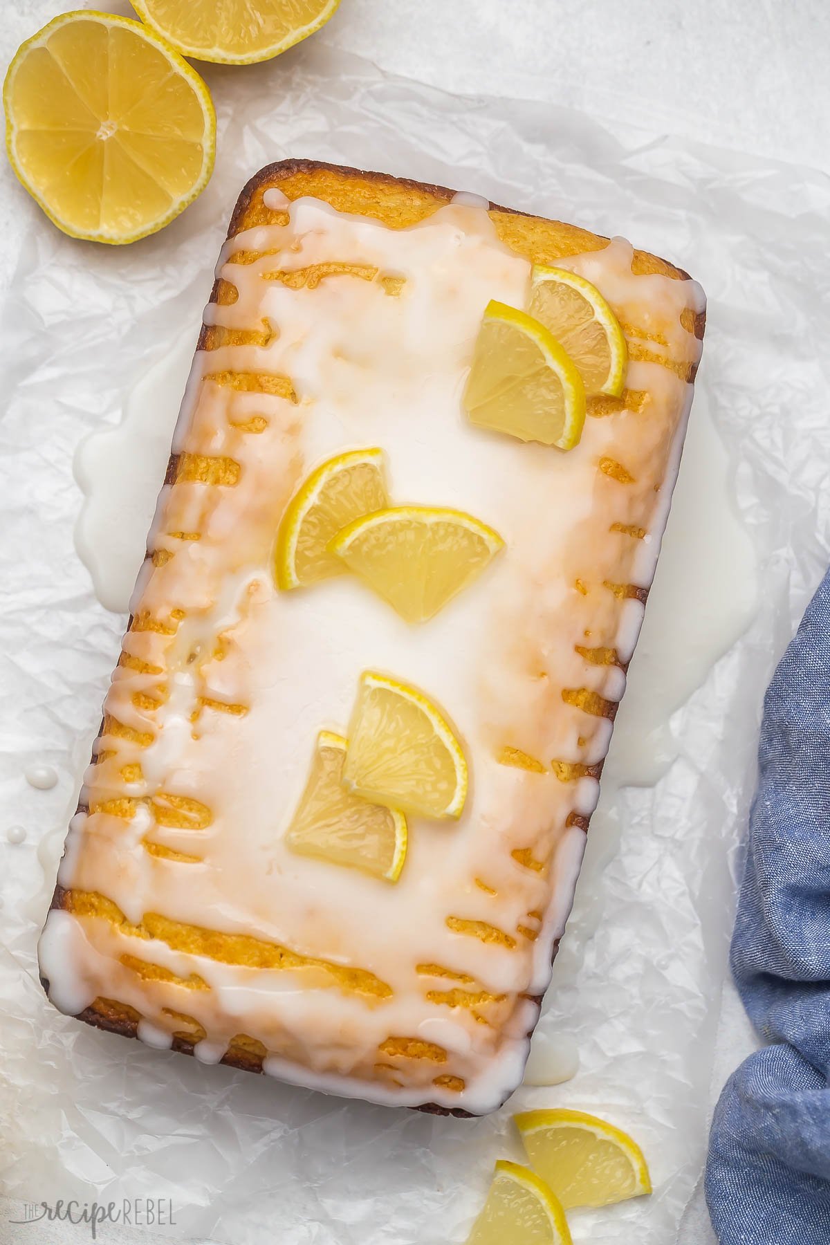 Overhead view of lemon bread loaf topped with glaze and lemon slices.