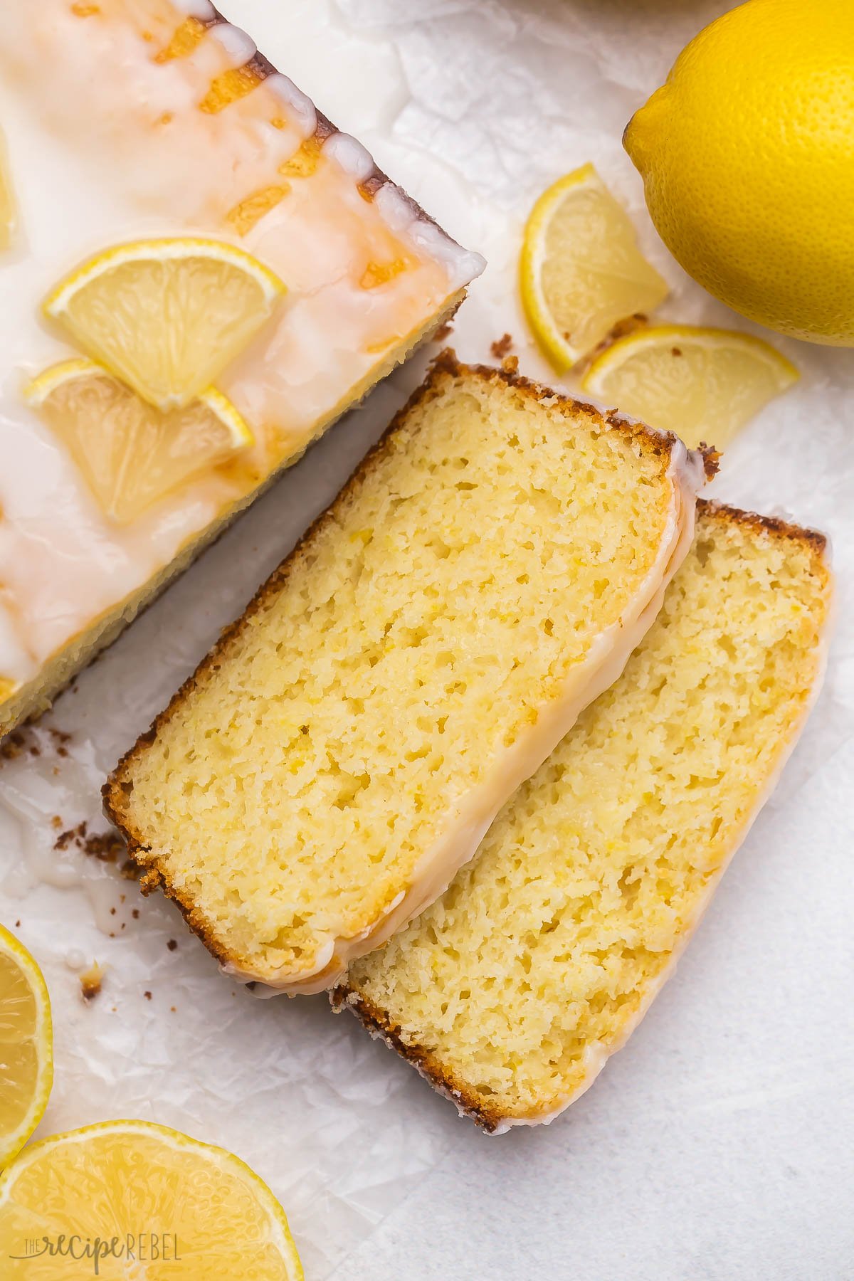 loaf of lemon bread with two pieces sliced on grey surface.