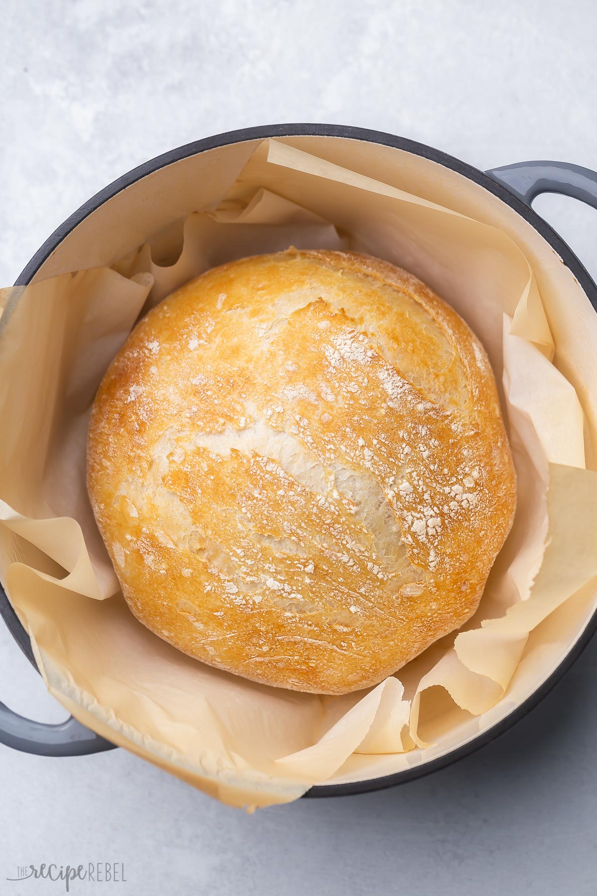 top view of a full loaf of no knead bread sitting in a dutch oven.