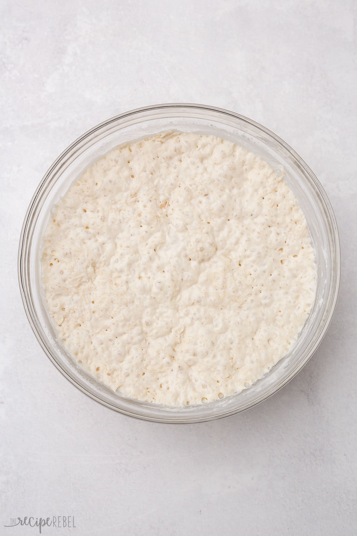 overhead shot of risen dough in a glass bowl.