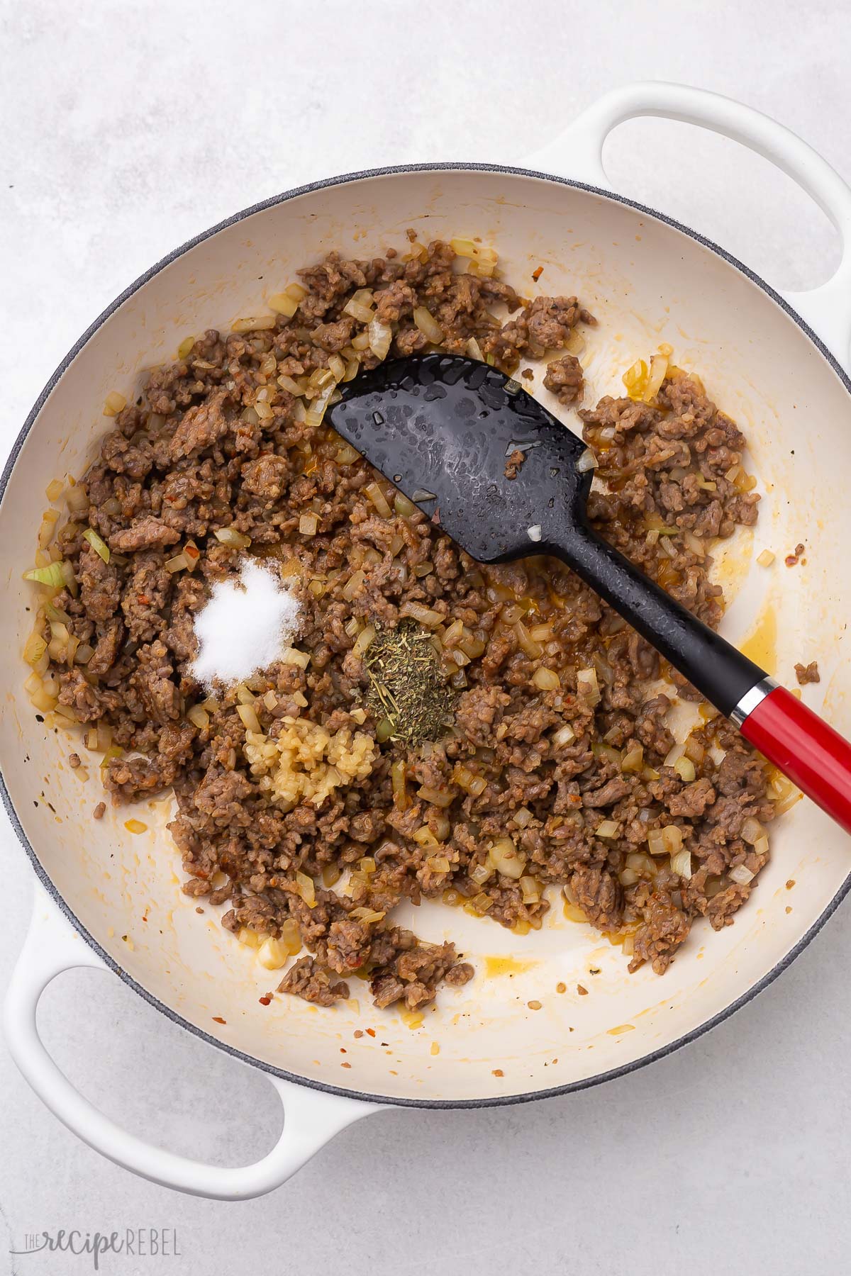 cooked ground sausage and spices in white pan.