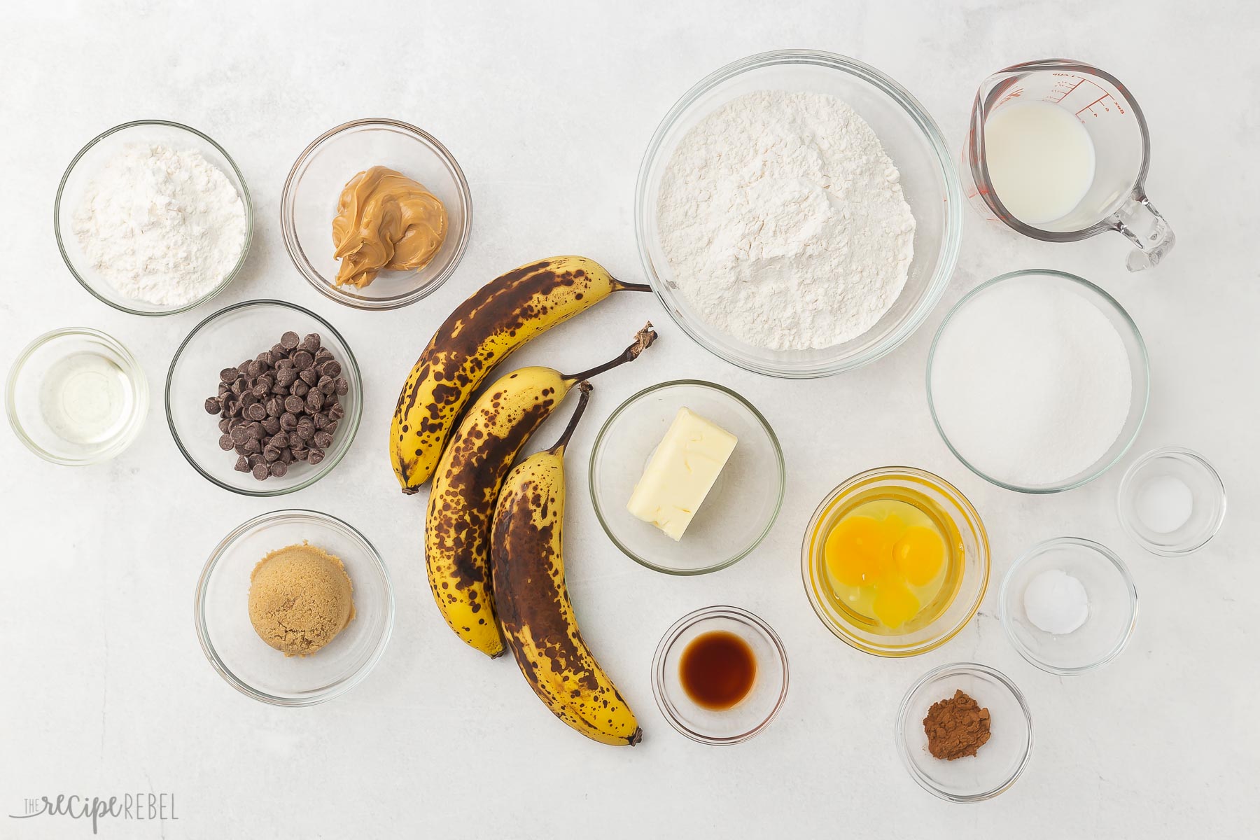 overhead view of peanut butter chocolate chip streusel banana bread ingredients in glass bowls.