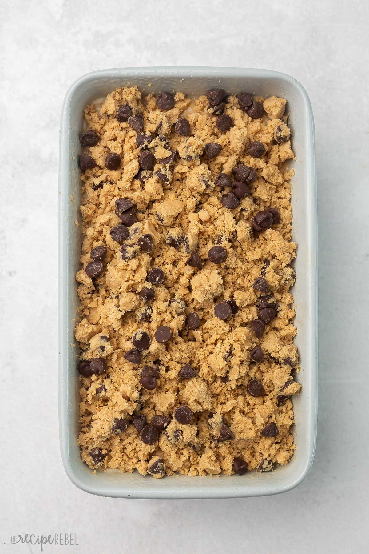 banana bread in grey loaf pan with streusel on top.