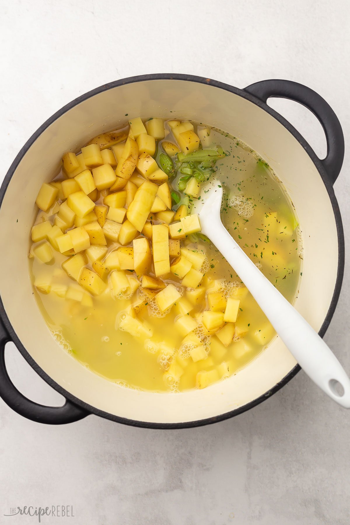 a large pot of uncooked potato leek soup ingredients.