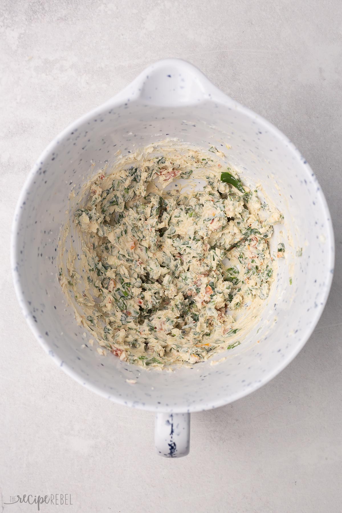 overhead view of spinach stuffing fully mixed in a mixing bowl.