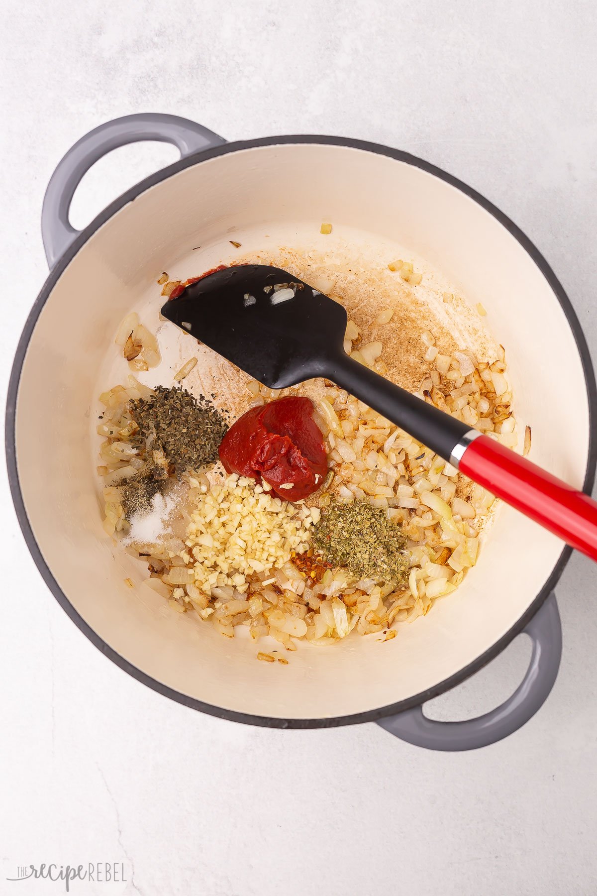 spice ingredients in dutch oven with onions.