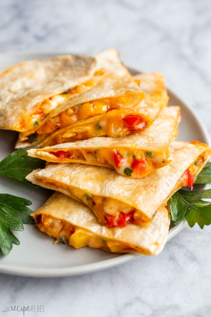 Close up photo of cheesy quesadillas slices on a plate on a grey plate.