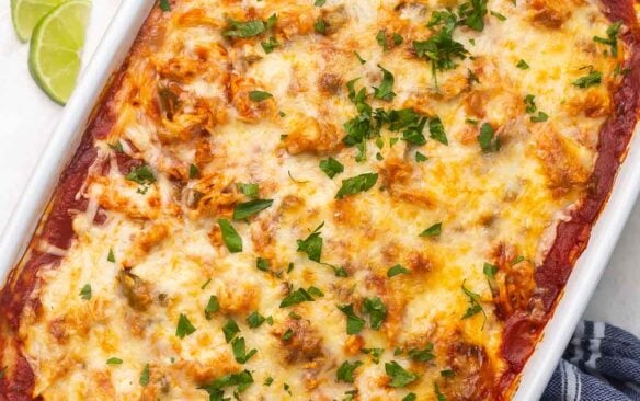 Top view of chicken enchilada casserole in a large white dish.