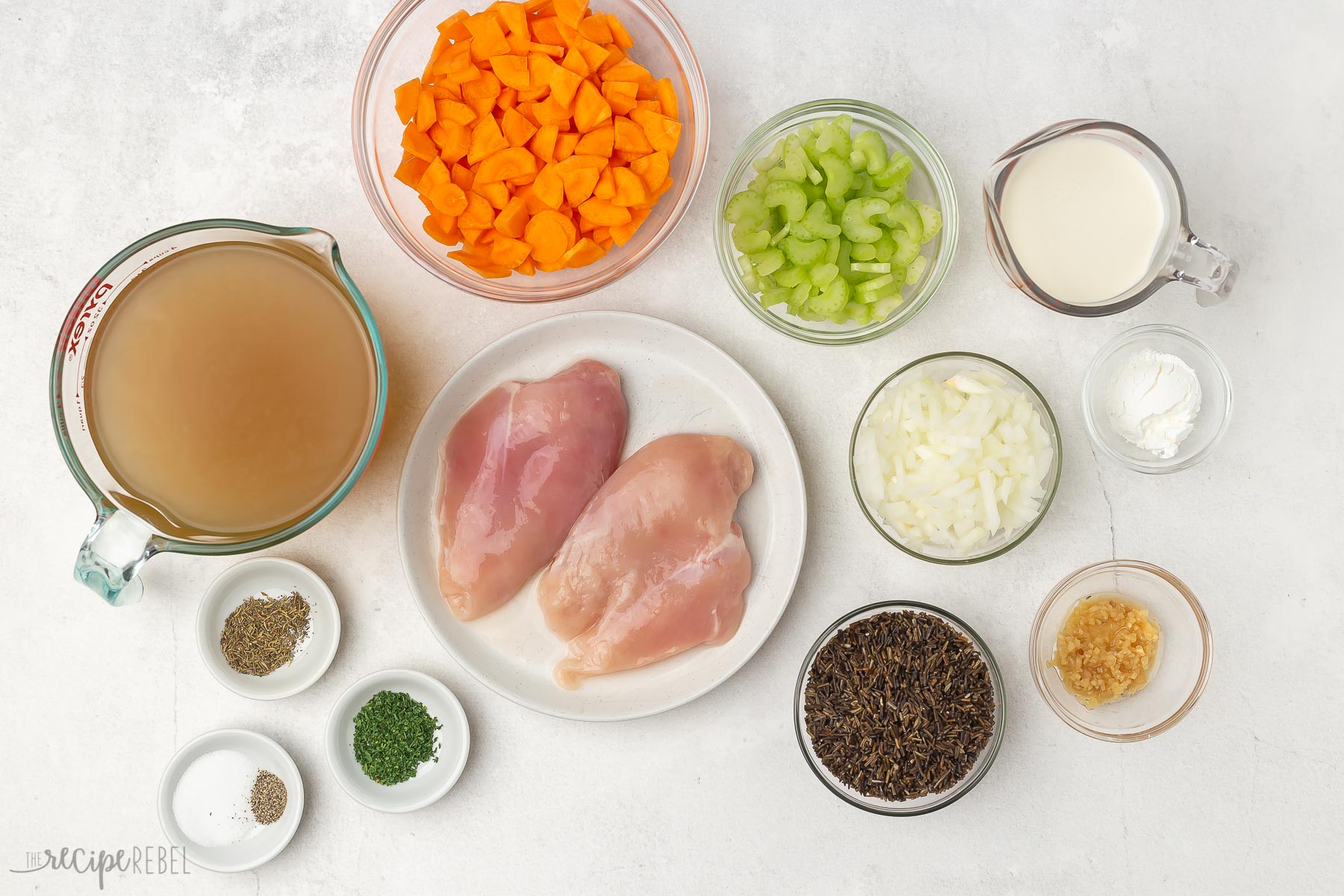 Top view of ingredients for wild rice soup in separate glass bowls. 