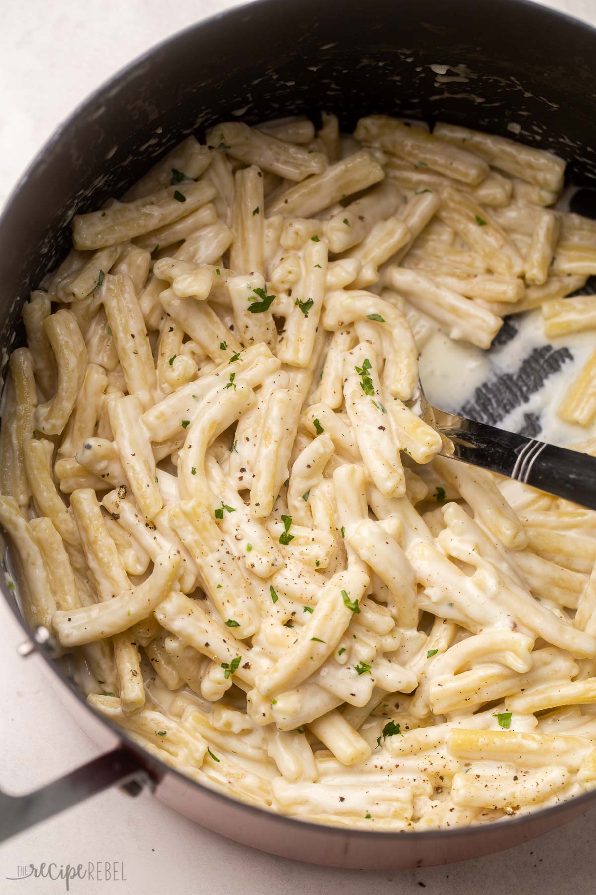 close shot of gemelli pasta garnished with cracked pepper and parsley.