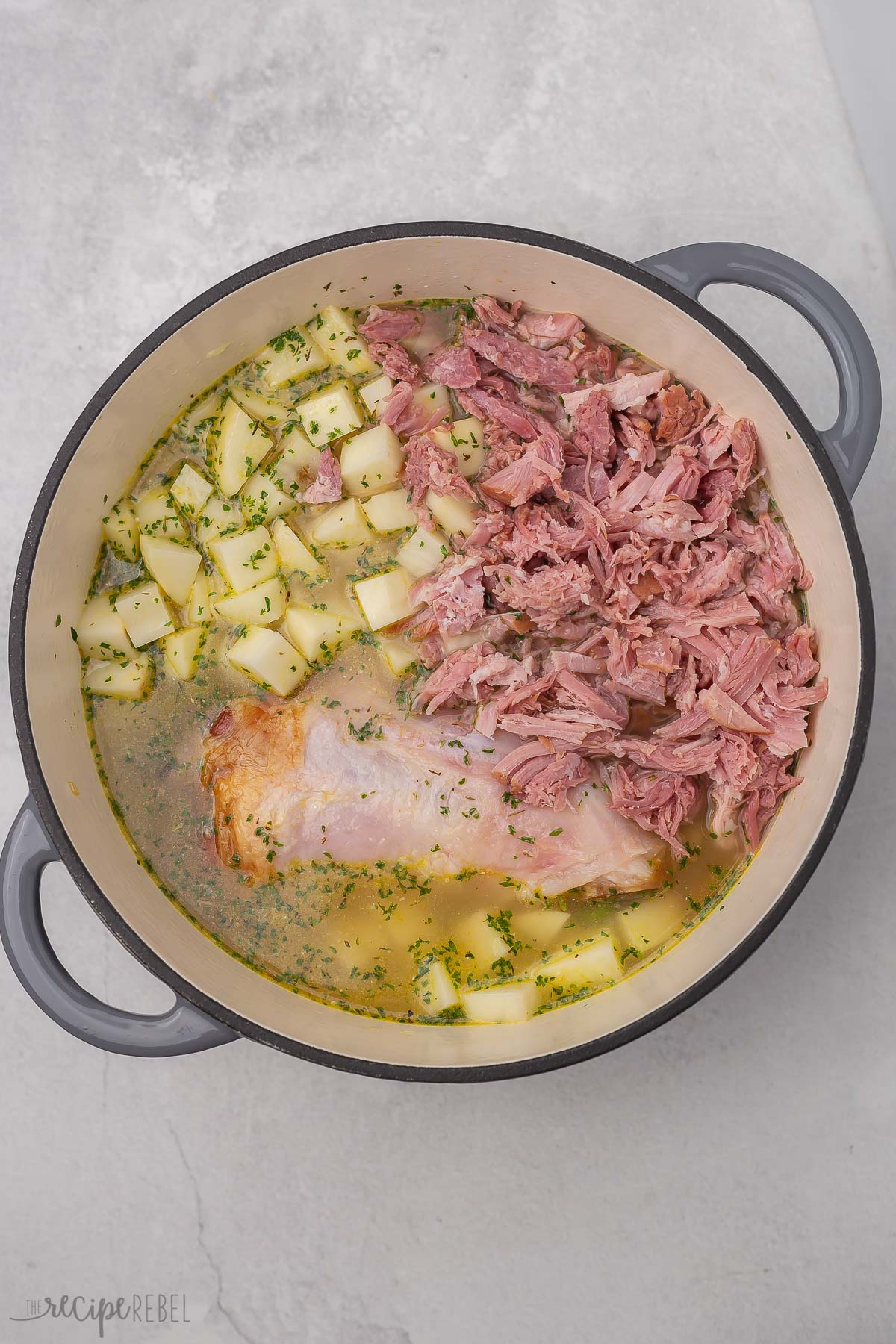 ham bone, shredded ham and potatoes added to soup pot.