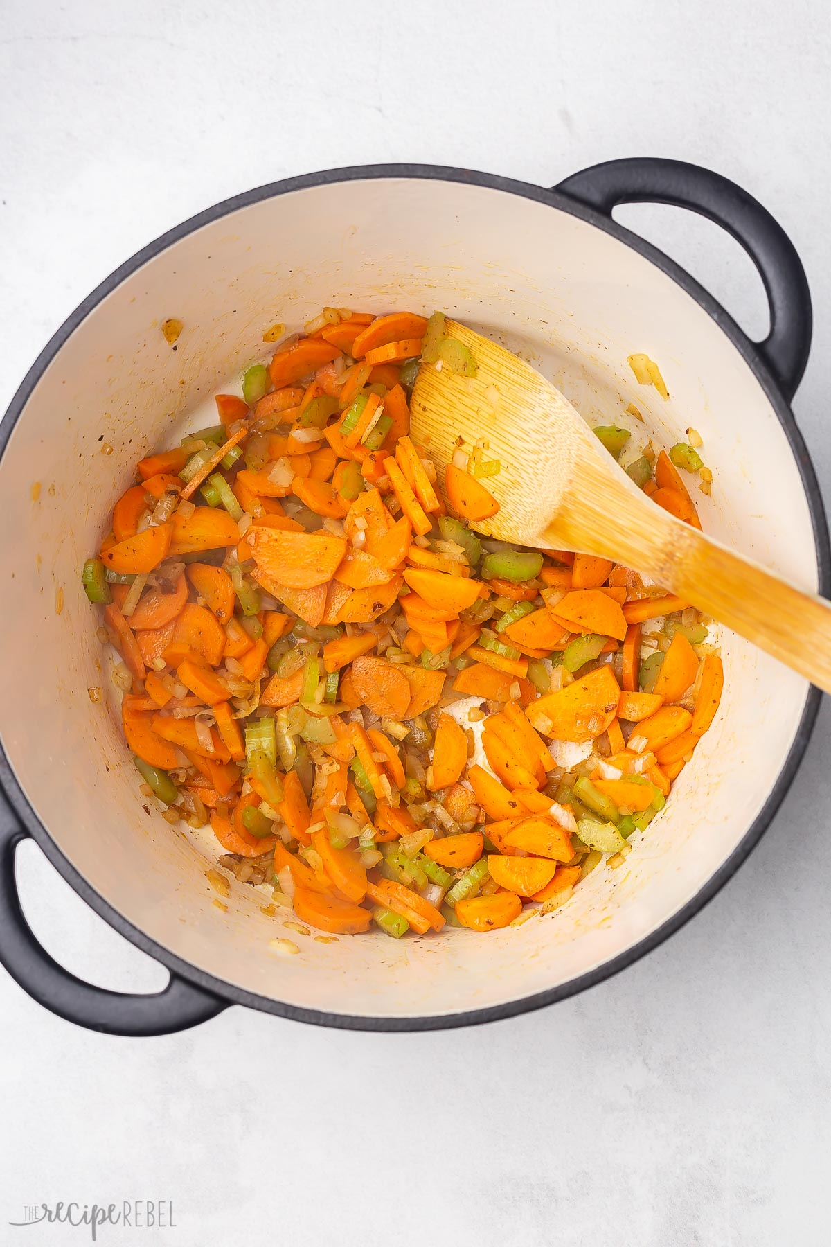 sauteed vegetables in pot with wooden ladel.