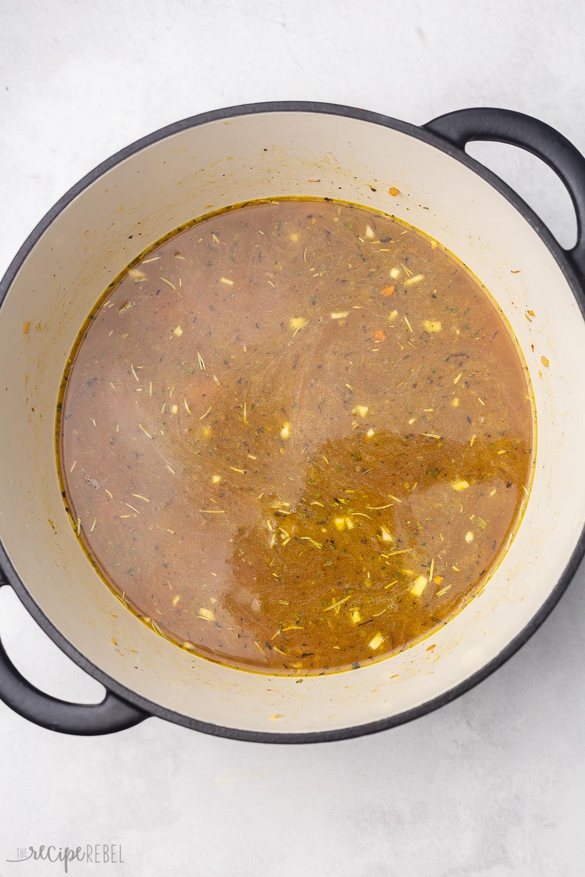 overhead view of pot with vegetables, spices and broth added.