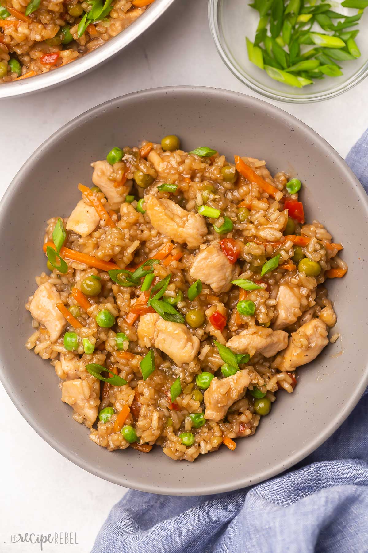 Top view of a bowl filled with teriyaki chicken with rice, garnished with green onions.