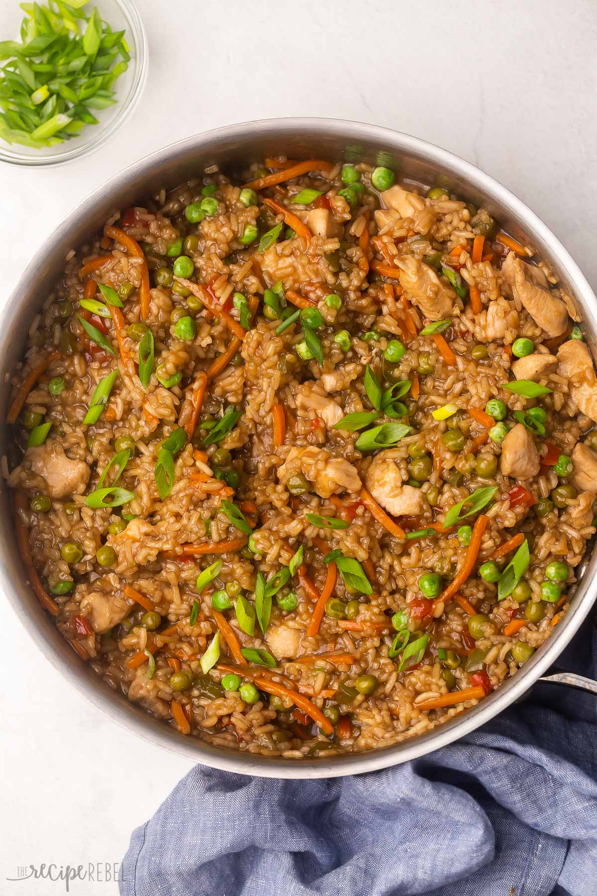 cooked pan of teriyaki chicken and rice with green onions sprinkled on top.