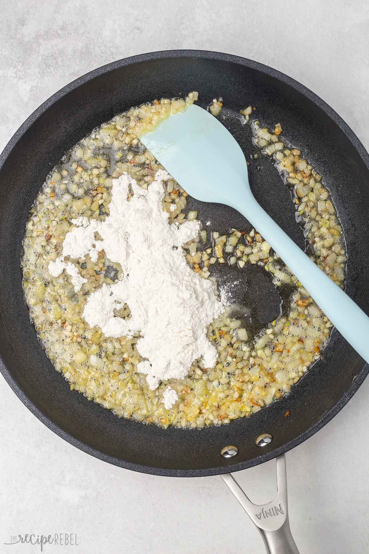 Top view of a skillet pan with garlic and yogurt in it. 