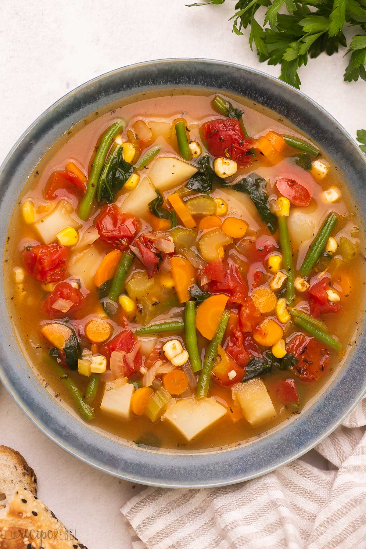 This Vegetable Soup, with fresh seasonal veggies and a flavorful broth, is a hearty and healthy soup recipe that takes 35 minutes to make and is perfect for warming you up on cold winter days! #soup #recipe | soup recipes | healthy dinner | easy recipe | healthy soup Top view of vegetable soup in a bowl.