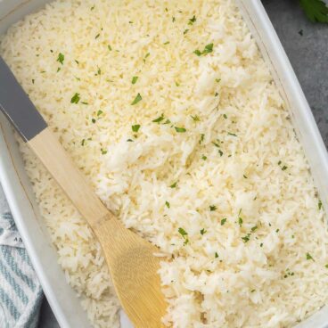 large dish of baked rice garnished with chopped parsley.