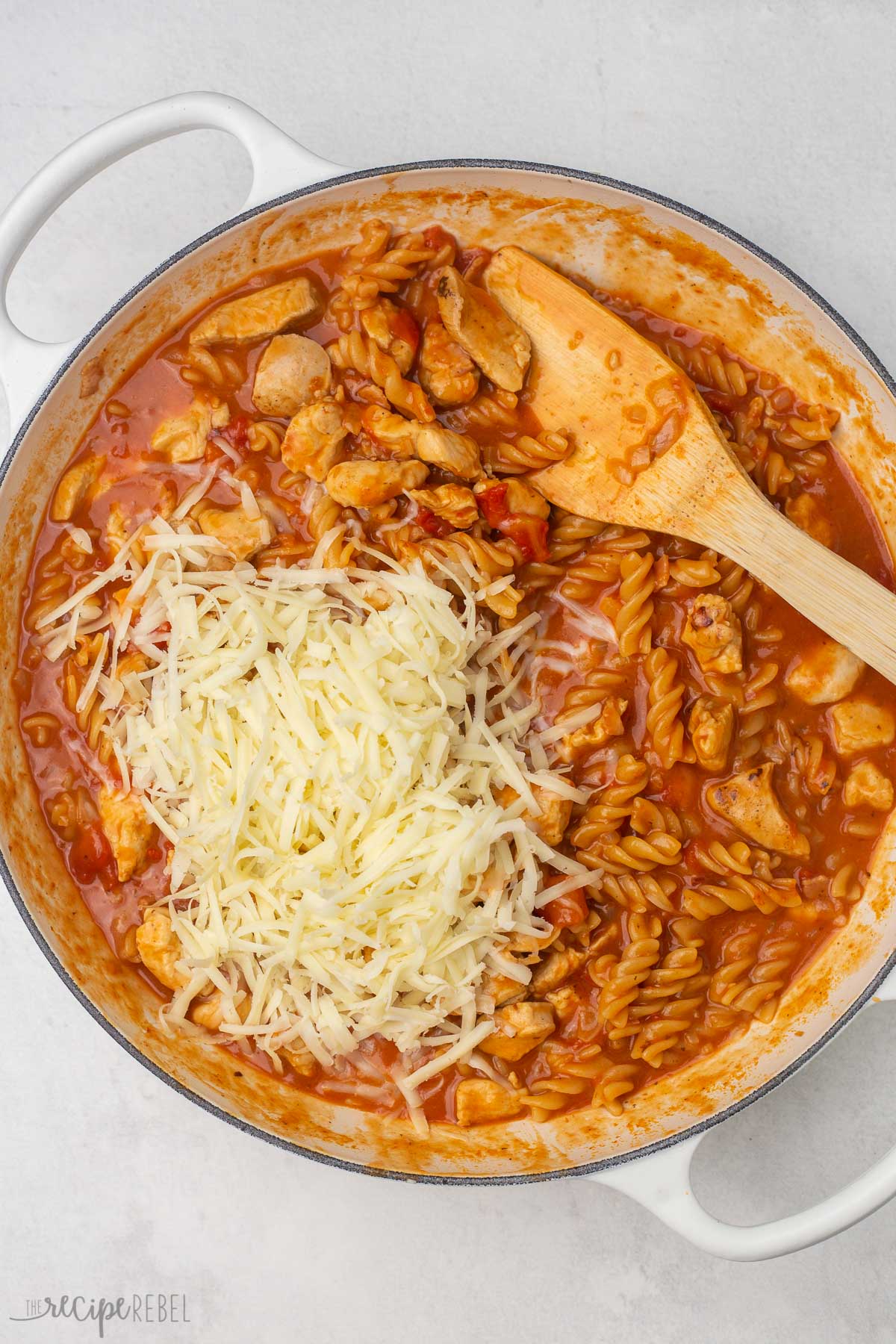 cooked dish of bbq chicken pasta with shredded mozzarella added on top.