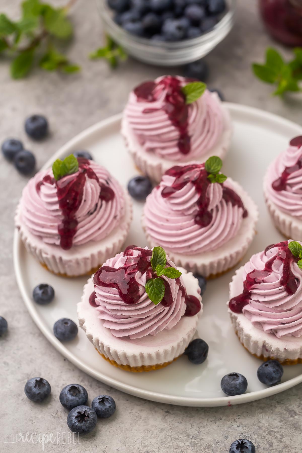 white plate with six blueberry cheesecake ice cream cupcakes.