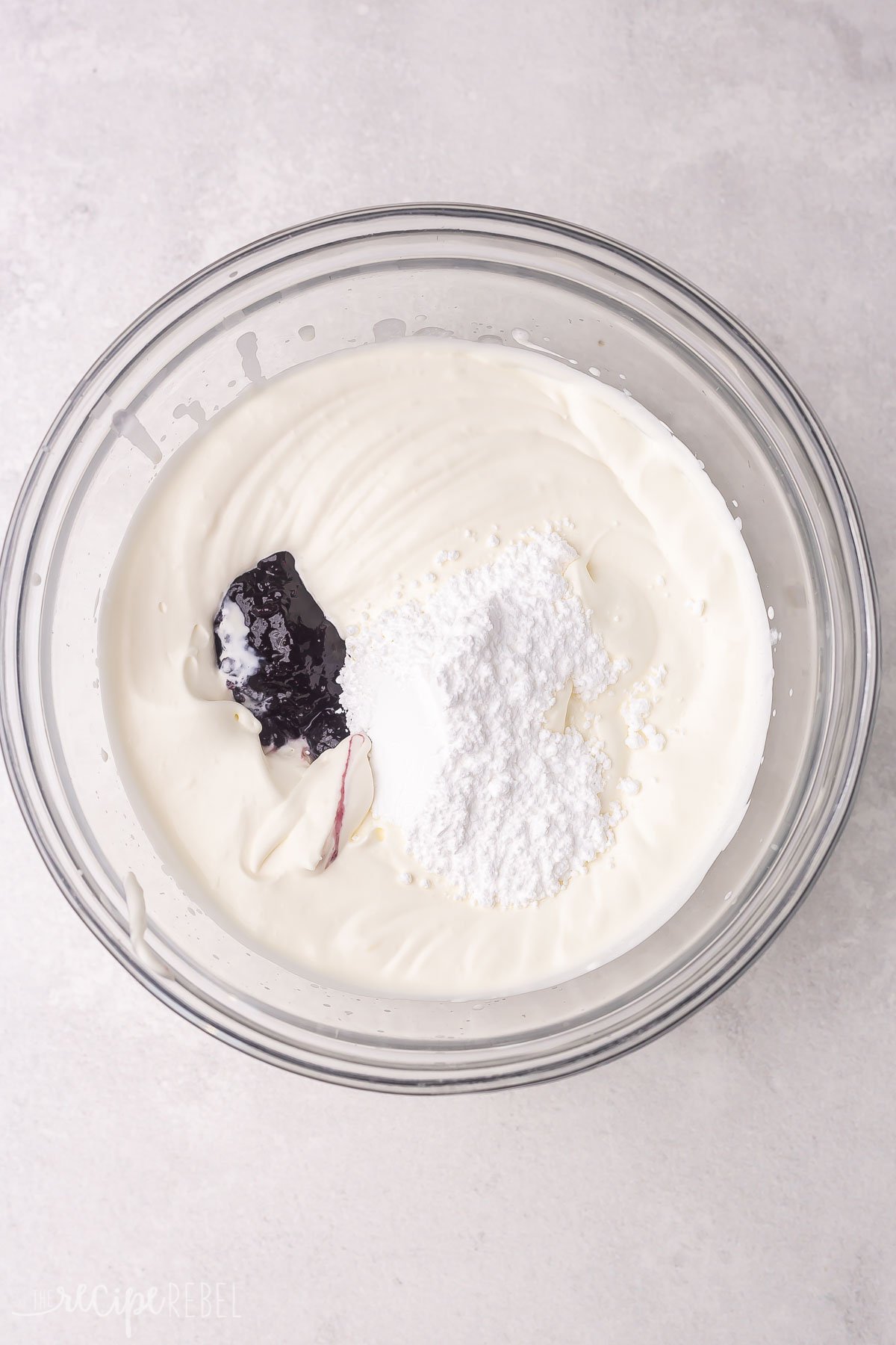 cream powdered sugar and blueberry jam in glass bowl.