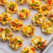 Top view of breakfast taco bites on a baking tray lined with parchment paper.