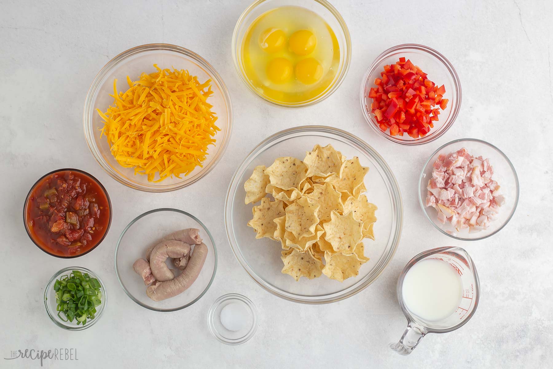 Top view of ingredients needed for breakfast taco bites in small glass bowls. 