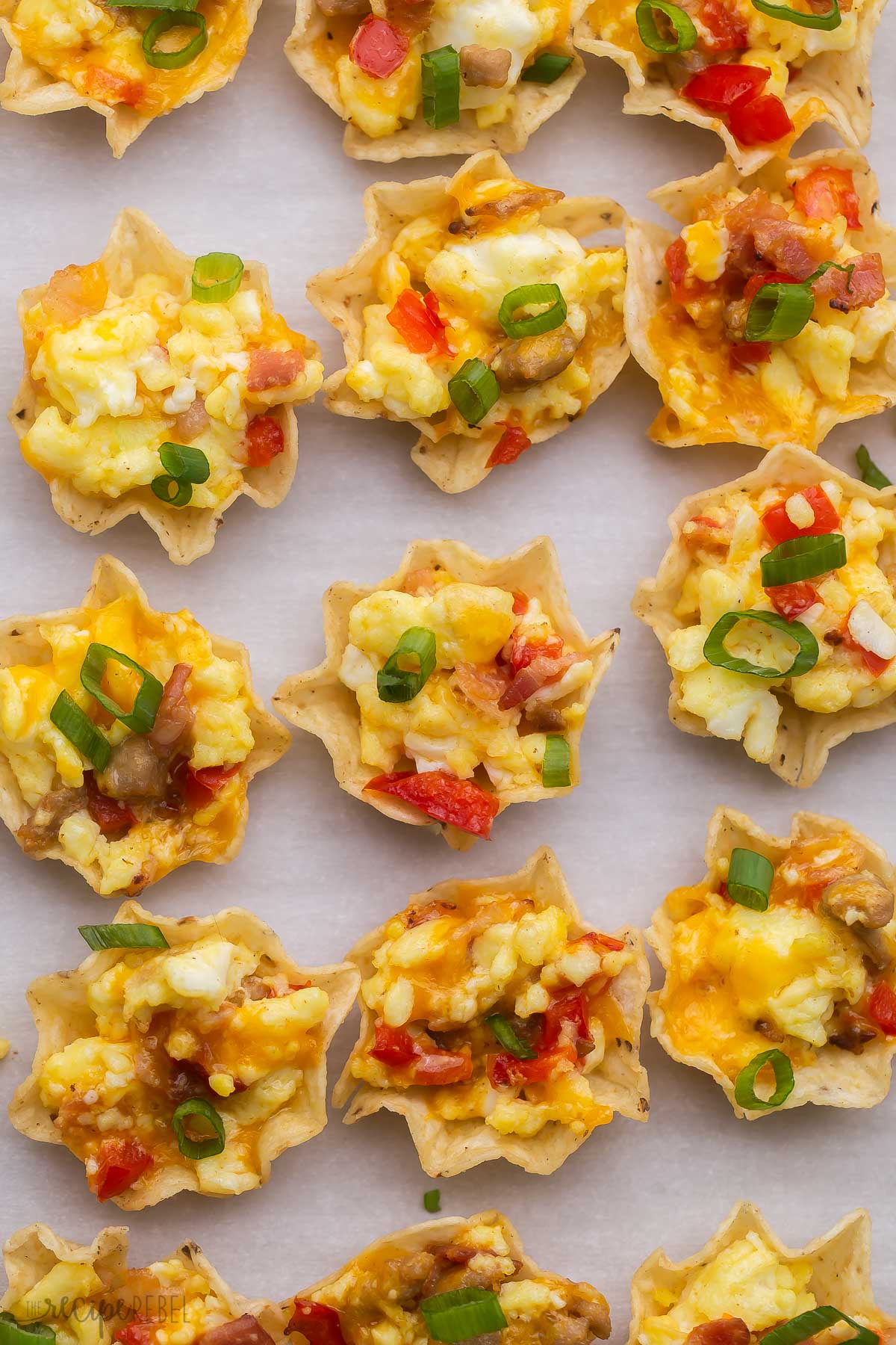 Close up of breakfast taco bites on a parchment lined baking tray. 