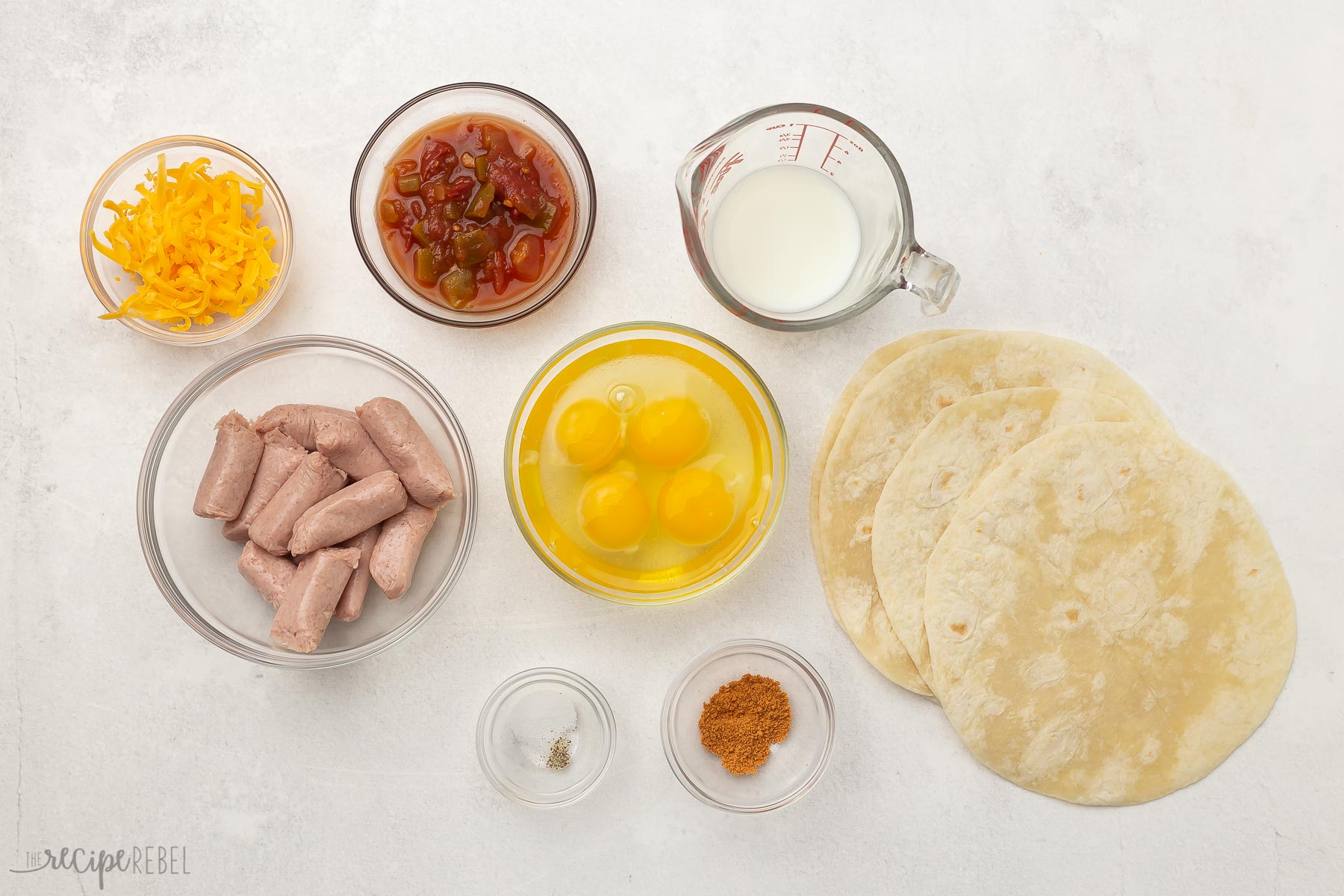 ingredients for breakfast tacos in glass bowls.