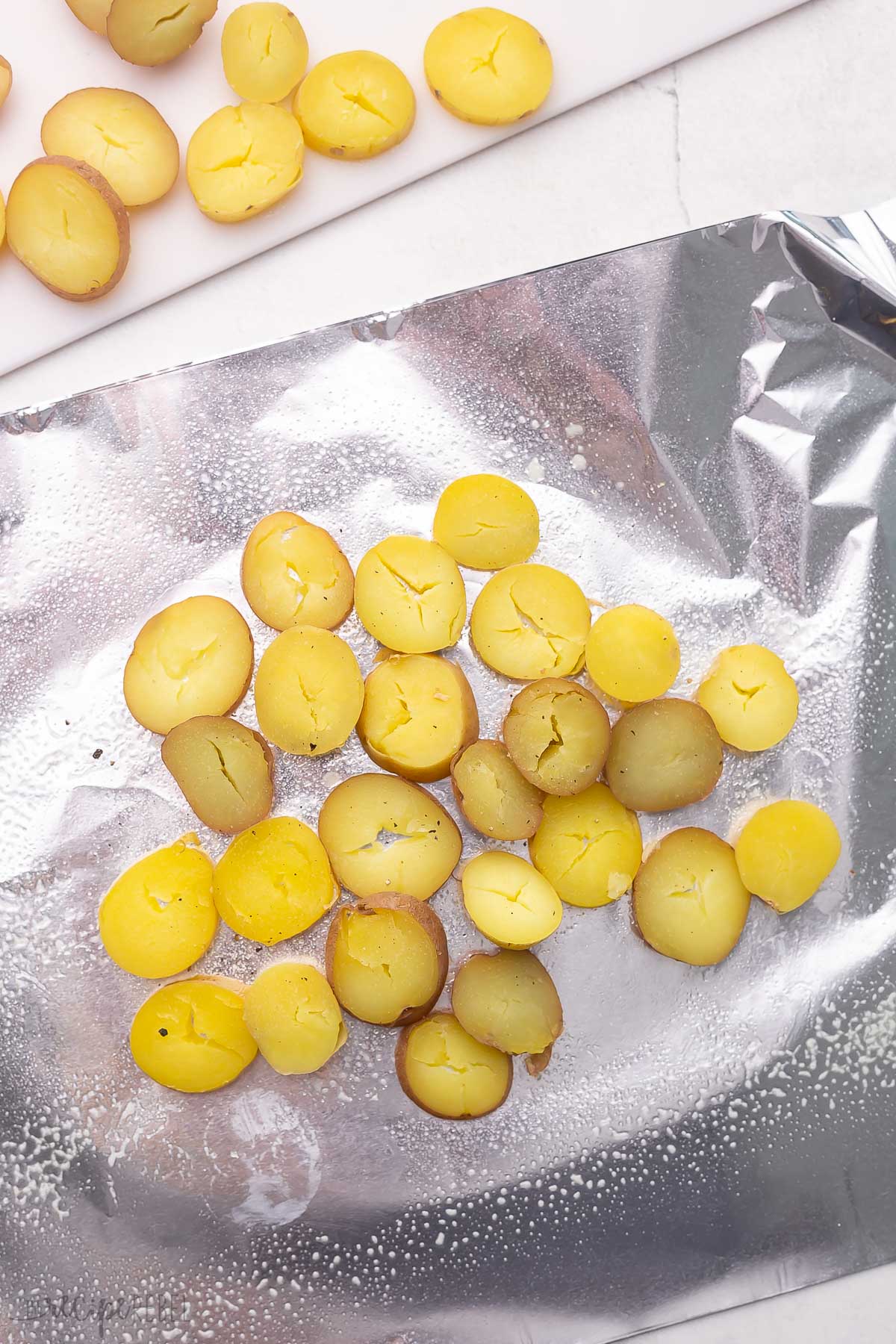 sliced small potatoes on greased aluminum foil.