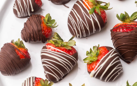 Top view of a plate full of chocolate covered strawberries.