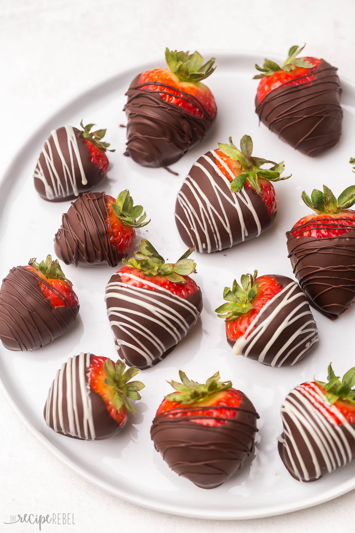Top view of a plate full of chocolate covered strawberries.