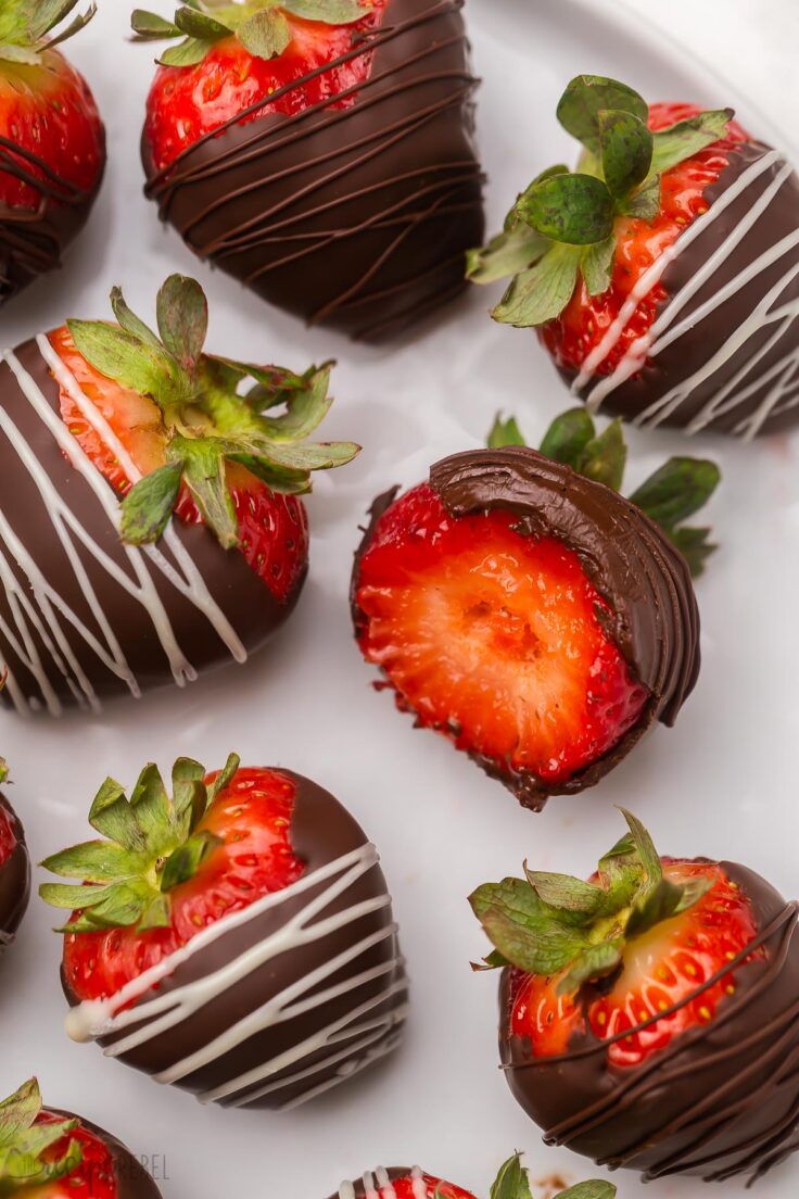 Easy Chocolate Covered Strawberries are the perfect Valentine's Day dessert or easy treat with lots of ways to customize and color them! #chocolate #strawberry #valentinesday #dessert #nobake Close up of chocolate covered strawberries on a white plate.