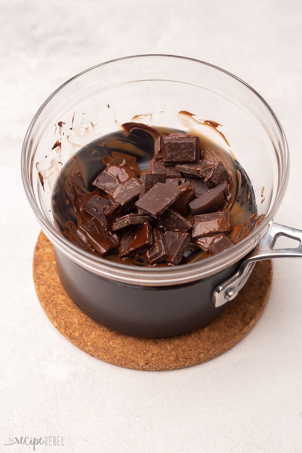 Chocolate melting in a glass bowl over a pot of hot water.