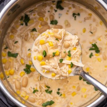 overhead view of instant pot chicken chilli being scooped out of instant pot.