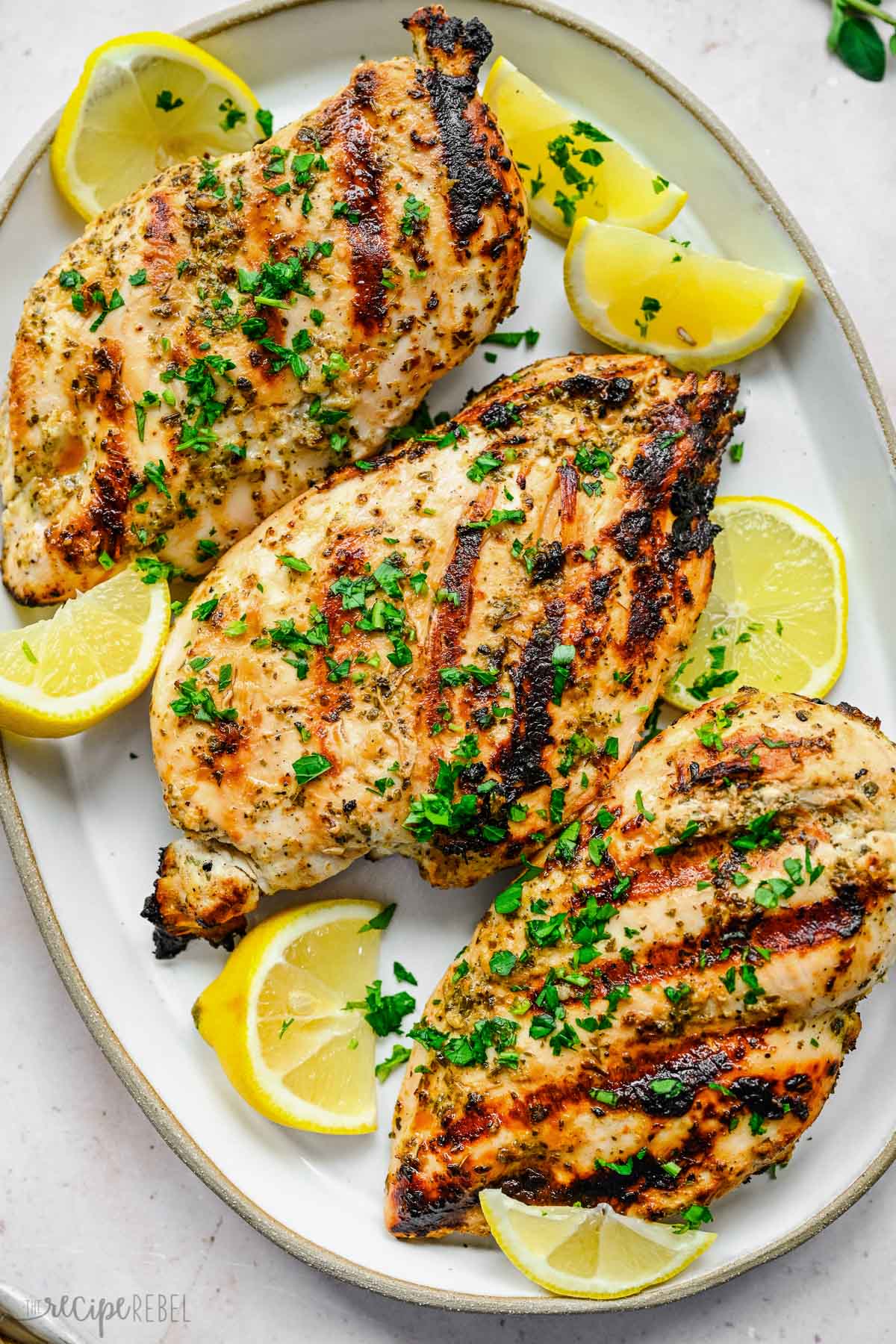 Top view of chicken on a platter that has had a Greek chicken marinade on it.