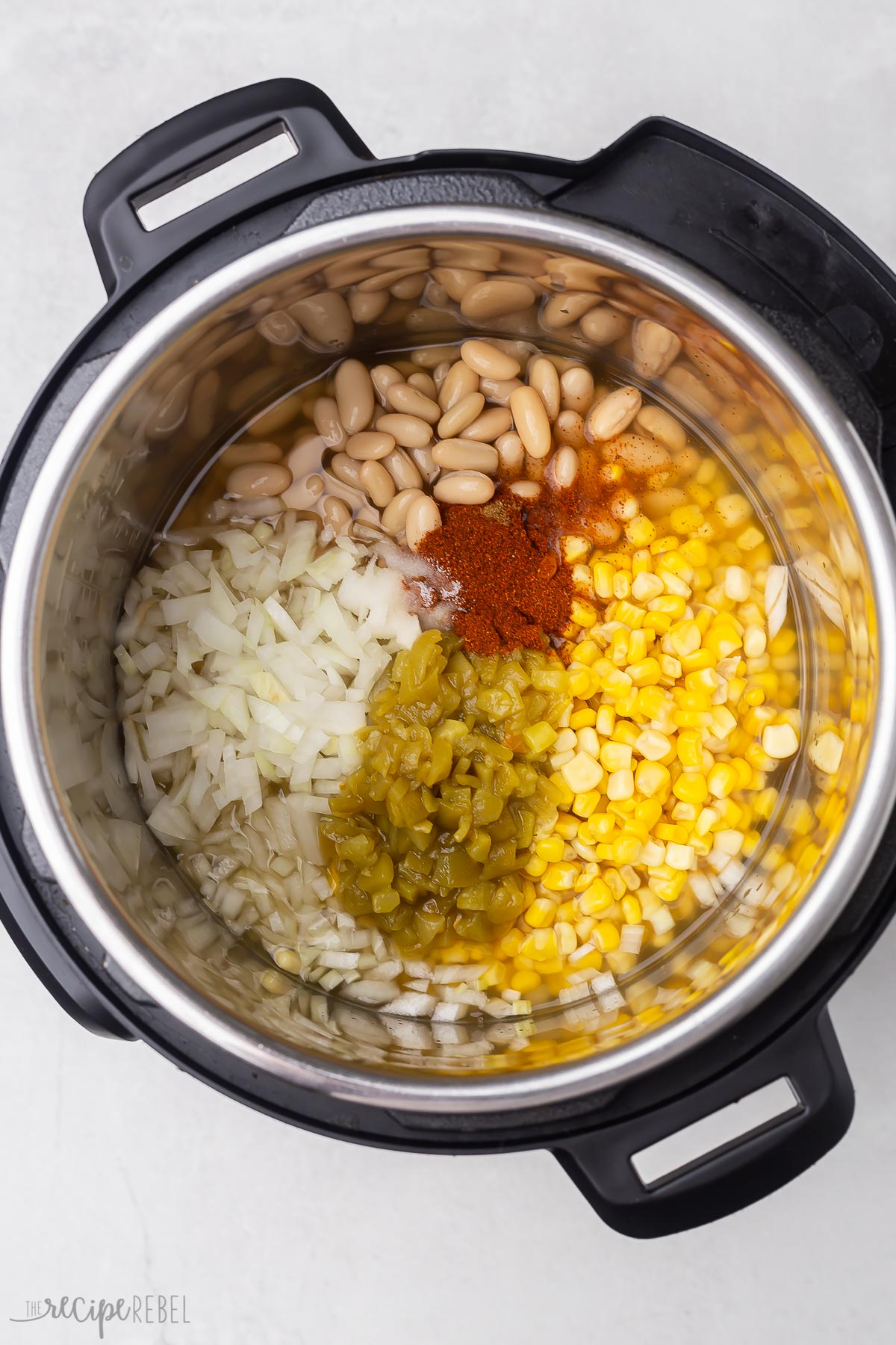 instant pot with uncooked vegetables and spices for instant pot chicken chilli.