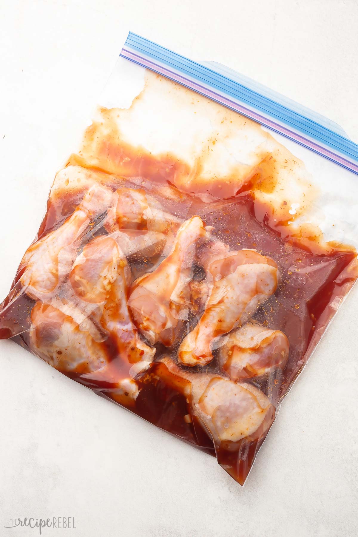 sealed bag with chicken drumsticks and maple glaze mixed.